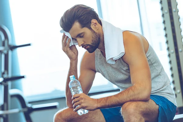 Giovane con bottiglia d'acqua in palestra — Foto Stock