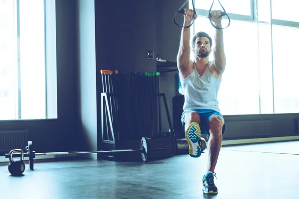 Spor salonunda egzersiz genç adam — Stok fotoğraf