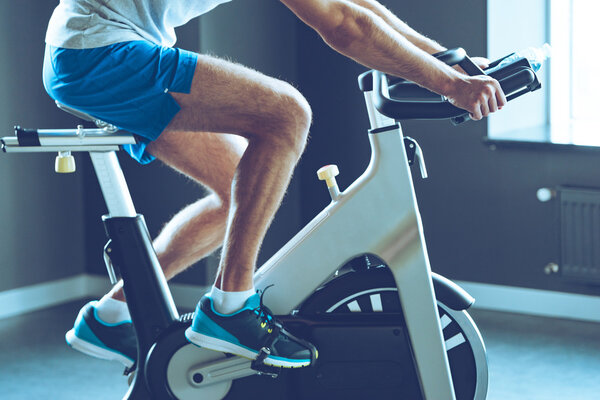 young man cycling at gym