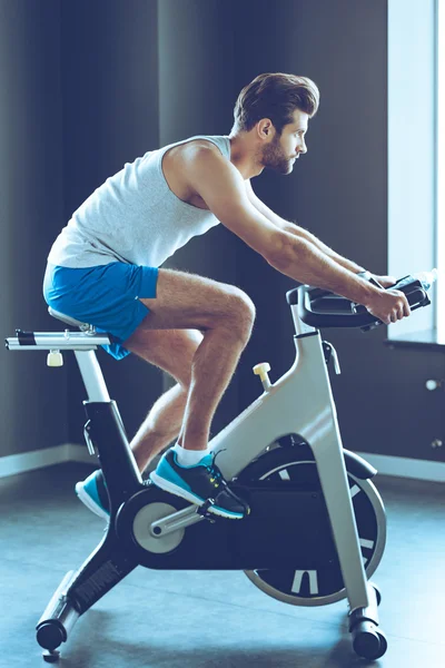 Joven ciclismo en el gimnasio —  Fotos de Stock