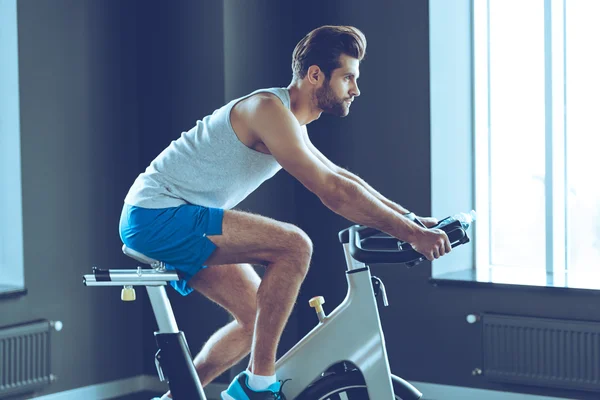 Jeune homme vélo à la salle de gym — Photo