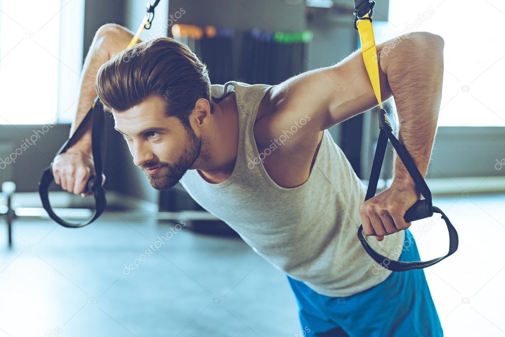 Young man exercising at gym Stock Photo by ©gstockstudio 102404514