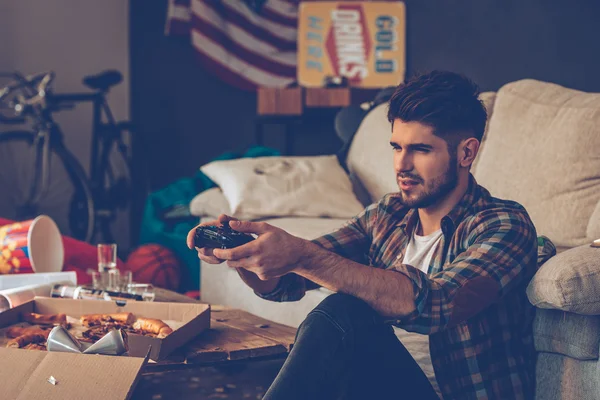 Jovem com joystick em quarto bagunçado — Fotografia de Stock