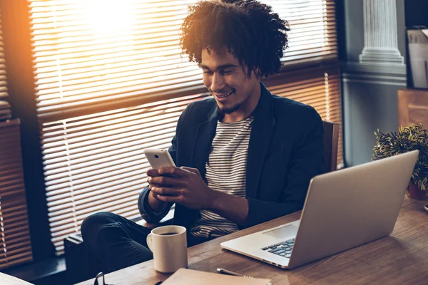 Afrikansk man använder smartphone — Stockfoto