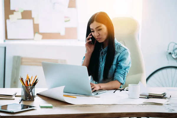 Asiatisk kvinna med laptop och telefon — Stockfoto