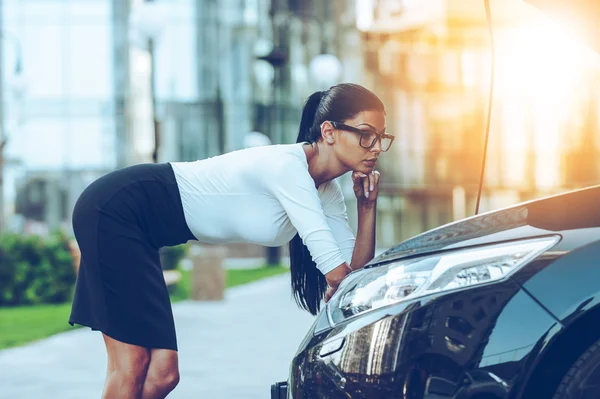 Affärskvinna lutar på öppnade fordon hoodof — Stockfoto