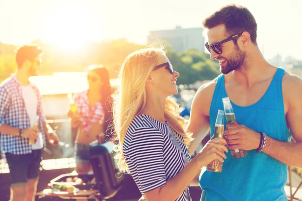 Jeune couple cliquetis lunettes avec bière — Photo