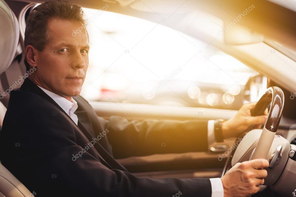 man in formalwear sitting in car