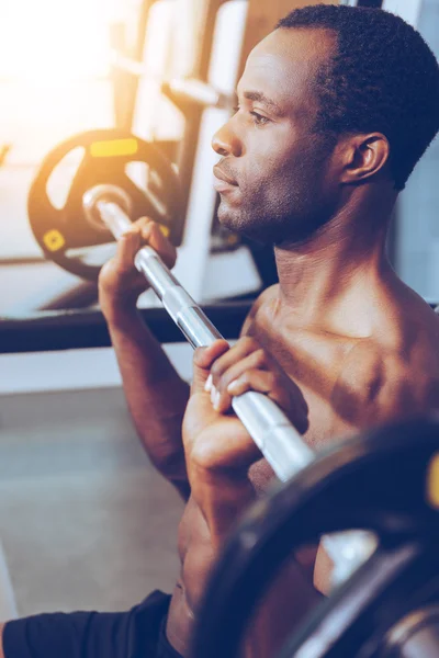 Young African man working out on bench press — Stock fotografie