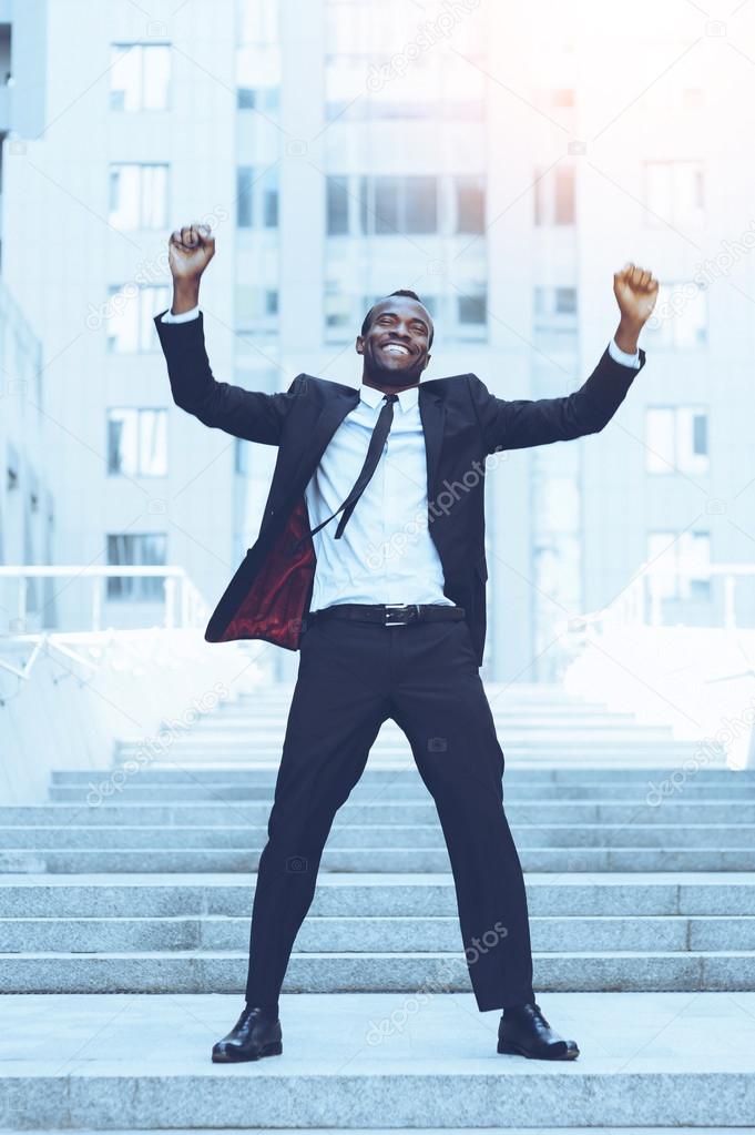 man in formalwear keeping arms raised