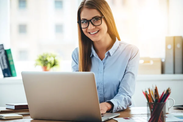 Donna in occhiali utilizzando il computer portatile — Foto Stock