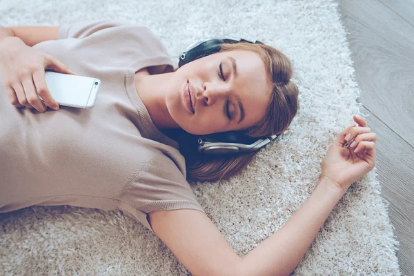 Vacker ung kvinna som lyssnar på musik — Stockfoto