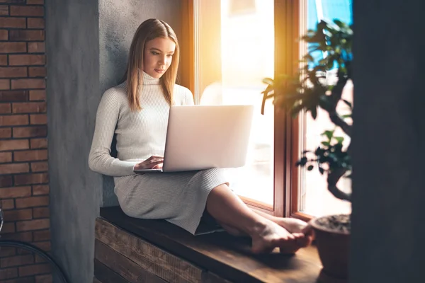 Ung kvinna som använder bärbar dator — Stockfoto