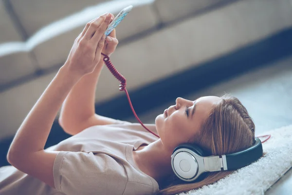 Vacker ung kvinna som lyssnar på musik — Stockfoto