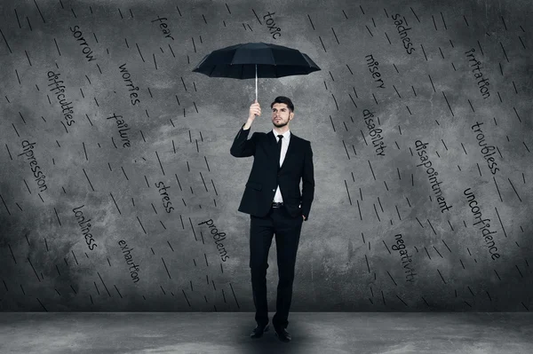 Jonge man in pak houden paraplu — Stockfoto