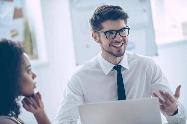 Joven discutiendo con compañeros de trabajo — Foto de Stock