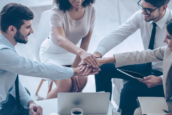 Young people holding hands at office — Stock Photo, Image