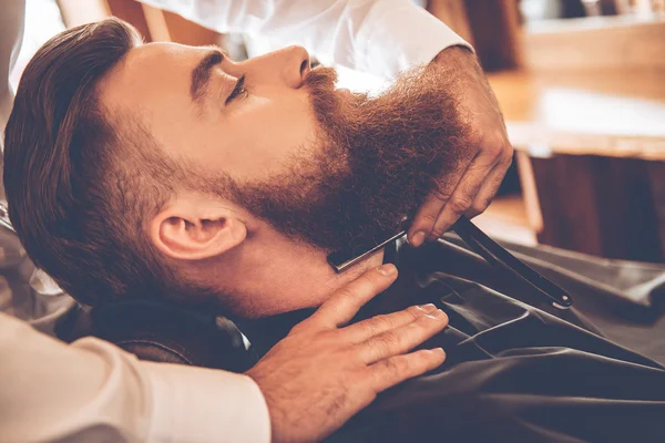 Bearded man getting shaved — Stock Photo, Image