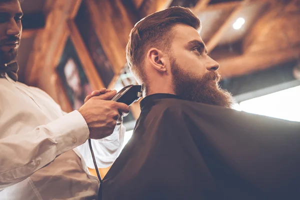 Young bearded man with hairdresser — Stockfoto