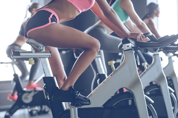 Young women cycling at gym — Stockfoto