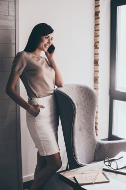 Neşeli kadın cep telefonuyla konuşuyor. 