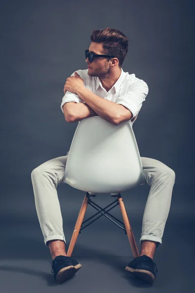 Handsome man in sunglasses sitting in chair — Stock Photo, Image