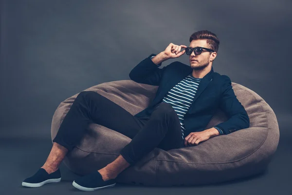 Przystojny mężczyzna siedzi na beanbag — Zdjęcie stockowe