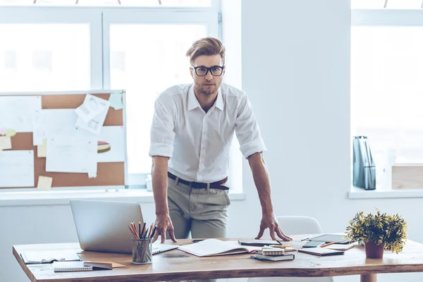 Man in glazen leunend naar de tabel in office — Stockfoto