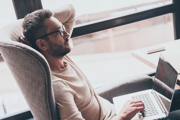 Hombre guapo usando su portátil — Foto de Stock