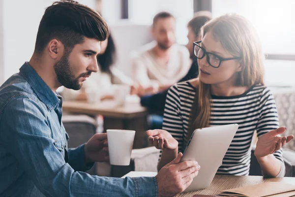 woman gesturing and looking at coworker