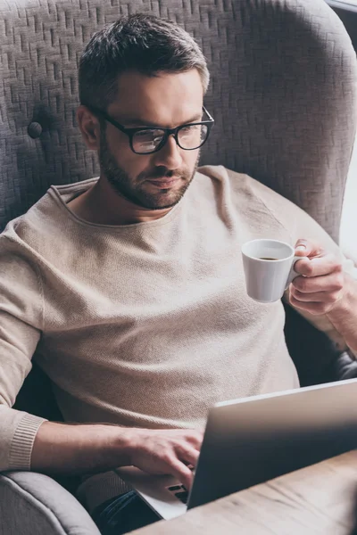 Homem bonito usando seu laptop — Fotografia de Stock