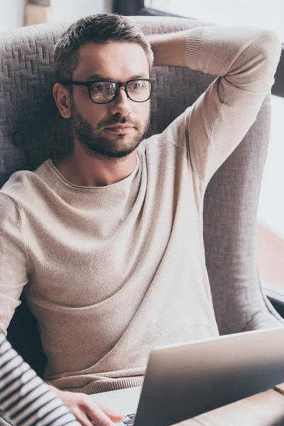 Handsome man using his laptop — Stock Photo, Image