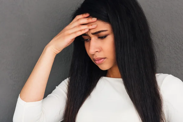 Frustrata giovane donna toccare fronte — Foto Stock