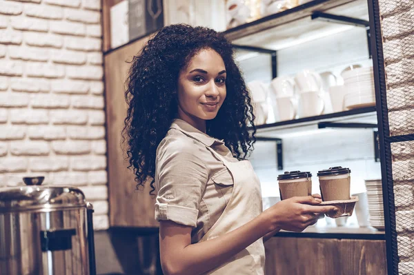 Mujer en delantal sosteniendo tazas de café — Foto de Stock