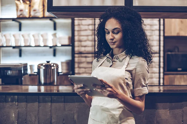 Mujer en delantal usando tableta digital — Foto de Stock