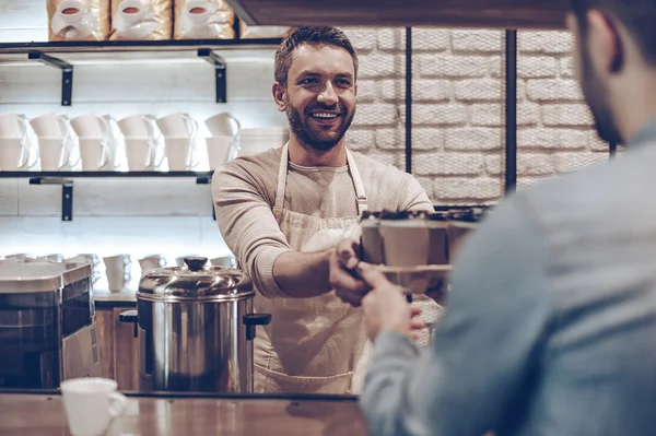 Barista passerende koffie kopjes — Stockfoto