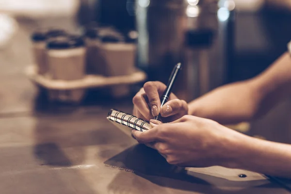 Young woman writing in notebook — Stock Photo, Image