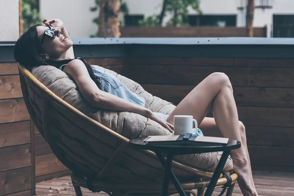 Mulher relaxante em uma grande cadeira confortável — Fotografia de Stock