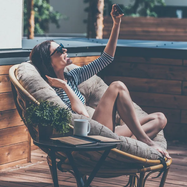 Mulher relaxante em uma grande cadeira confortável — Fotografia de Stock