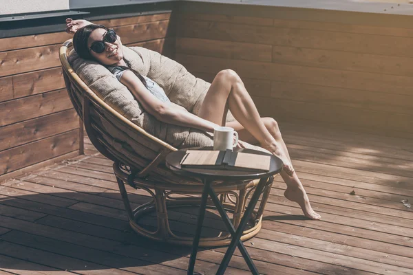 Vrouw ontspannen in een grote comfortabele stoel — Stockfoto