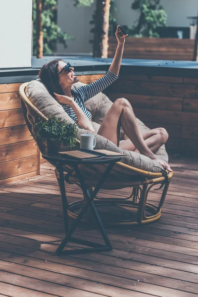 Femme se détendre dans une grande chaise confortable — Photo