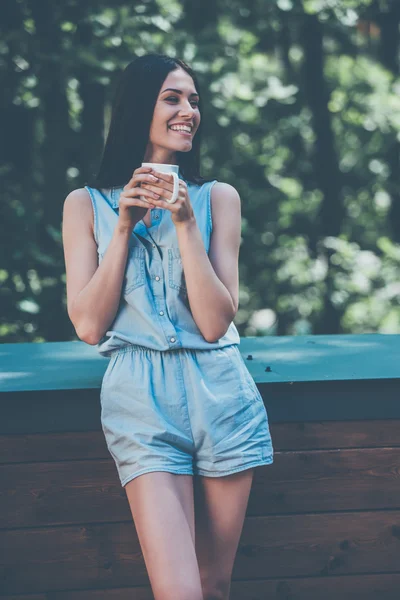Женщина пьет кофе и улыбается — стоковое фото