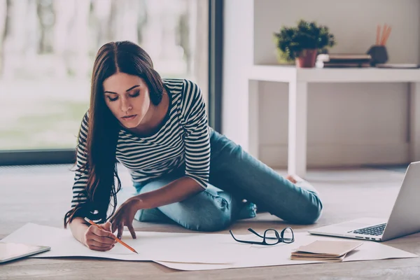 woman drawing something on blueprint