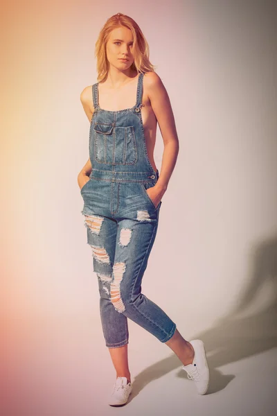 Young woman in jeans overalls — Stock Photo, Image