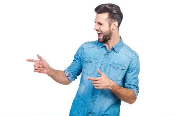 Homem de camisa jeans apontando para longe — Fotografia de Stock