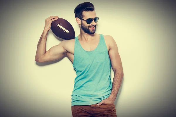 Man in zonnebril uitvoering American Football Ball — Stockfoto