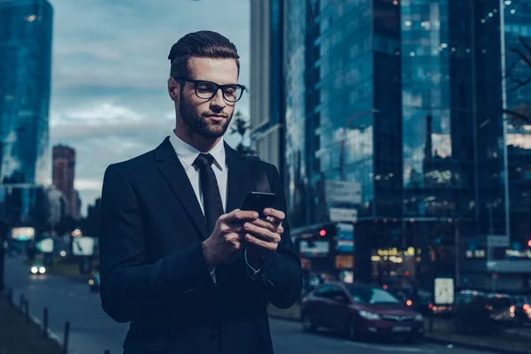 Hombre de negocios en ropa formal sosteniendo el teléfono inteligente —  Fotos de Stock