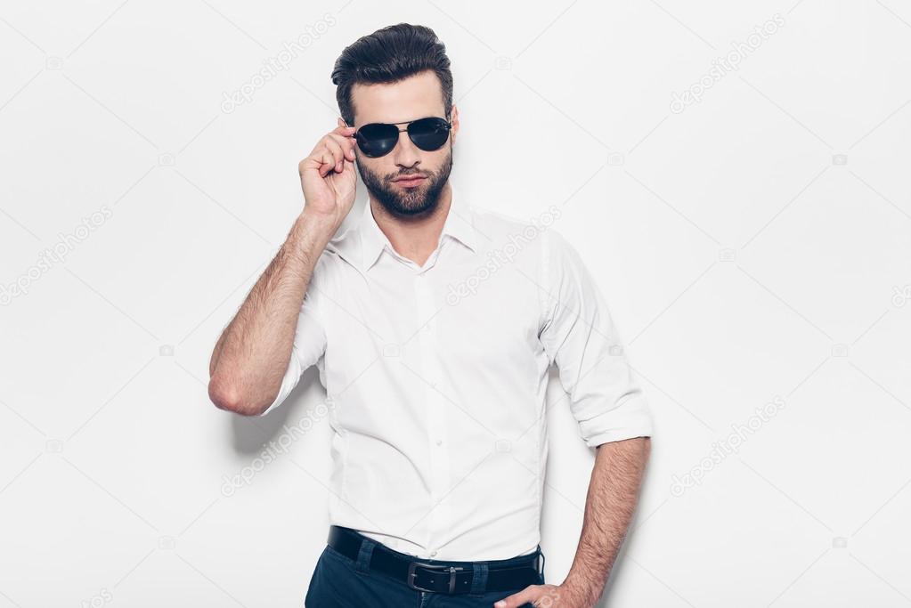 man in white shirt adjusting his sunglasses