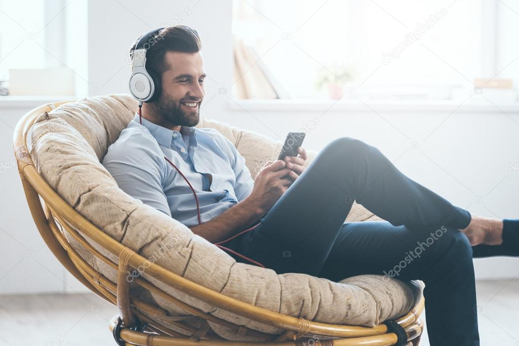 man in headphones looking at his smart phone
