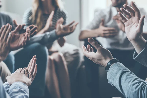 Les gens applaudissent tout en étant assis en cercle ensemble — Photo